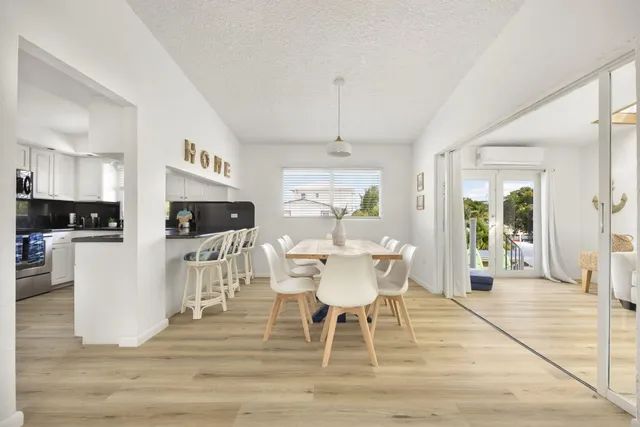 a dining room with furniture a rug a potted plant and a chandelier