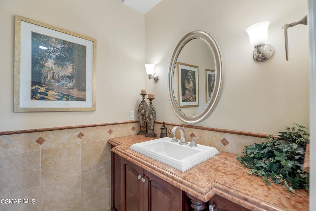 6717 Aspen Hills Drive Moorpark, CA 93021 - Photo 14 of 44 a bathroom with a granite countertop sink and a mirror