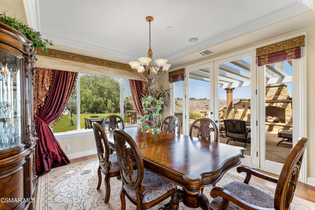 6717 Aspen Hills Drive Moorpark, CA 93021 - Photo 17 of 44 a dining room with furniture a chandelier and wooden floor