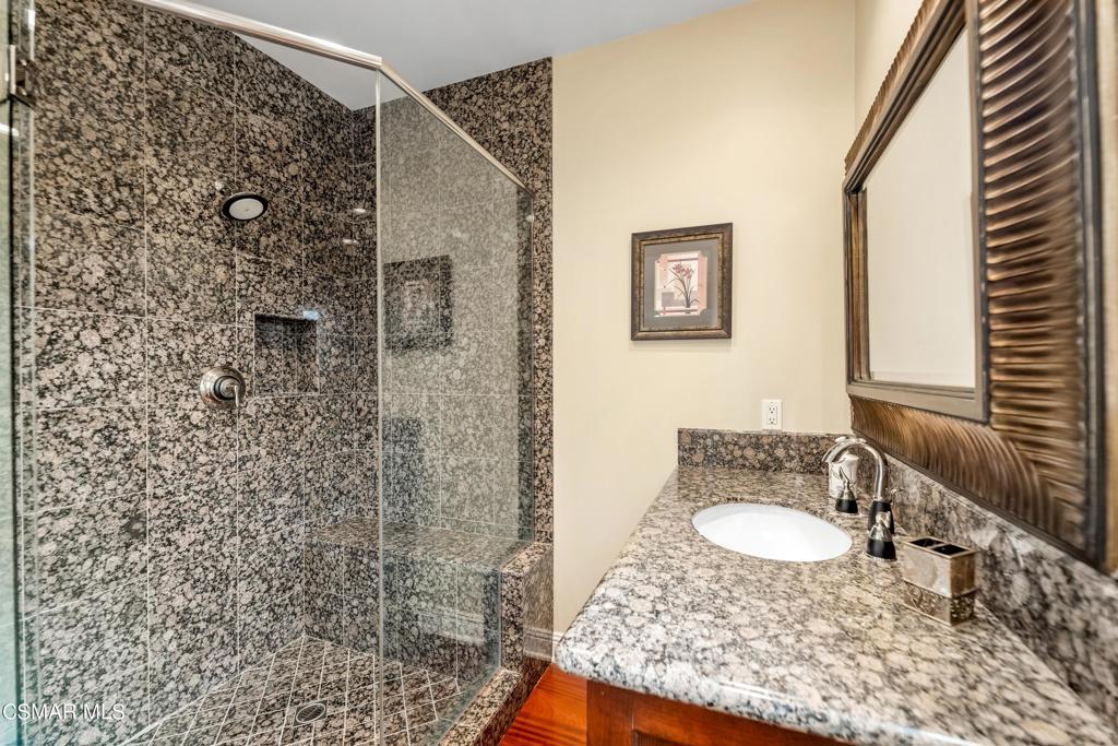 6717 Aspen Hills Drive Moorpark, CA 93021 - Photo 21 of 44 a bathroom with a granite countertop sink a mirror and shower