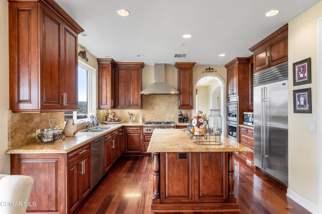 6717 Aspen Hills Drive Moorpark, CA 93021 - Photo 8 of 44 a kitchen with stainless steel appliances granite countertop wooden cabinets a sink and dishwasher a stove with wooden floor