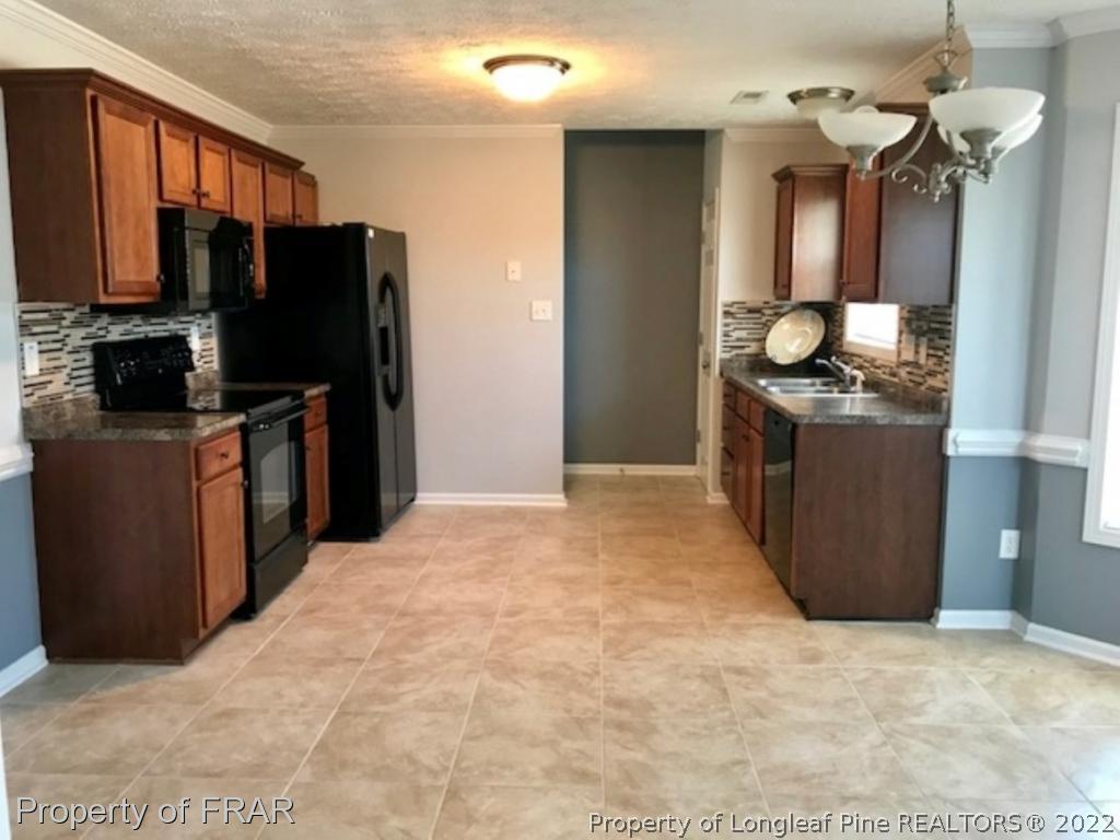 2309 Chasewater Road Fayetteville, NC 28306 - Photo 5 of 31 a kitchen with stainless steel appliances granite countertop a refrigerator a stove and a sink