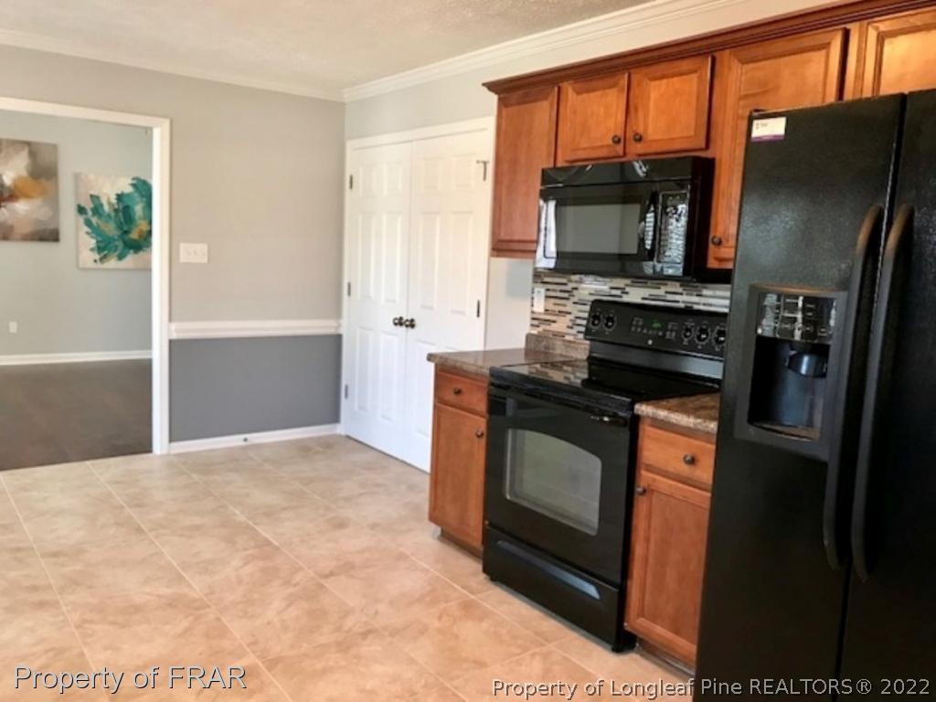 2309 Chasewater Road Fayetteville, NC 28306 - Photo 6 of 31 a kitchen with stainless steel appliances granite countertop a refrigerator stove and microwave