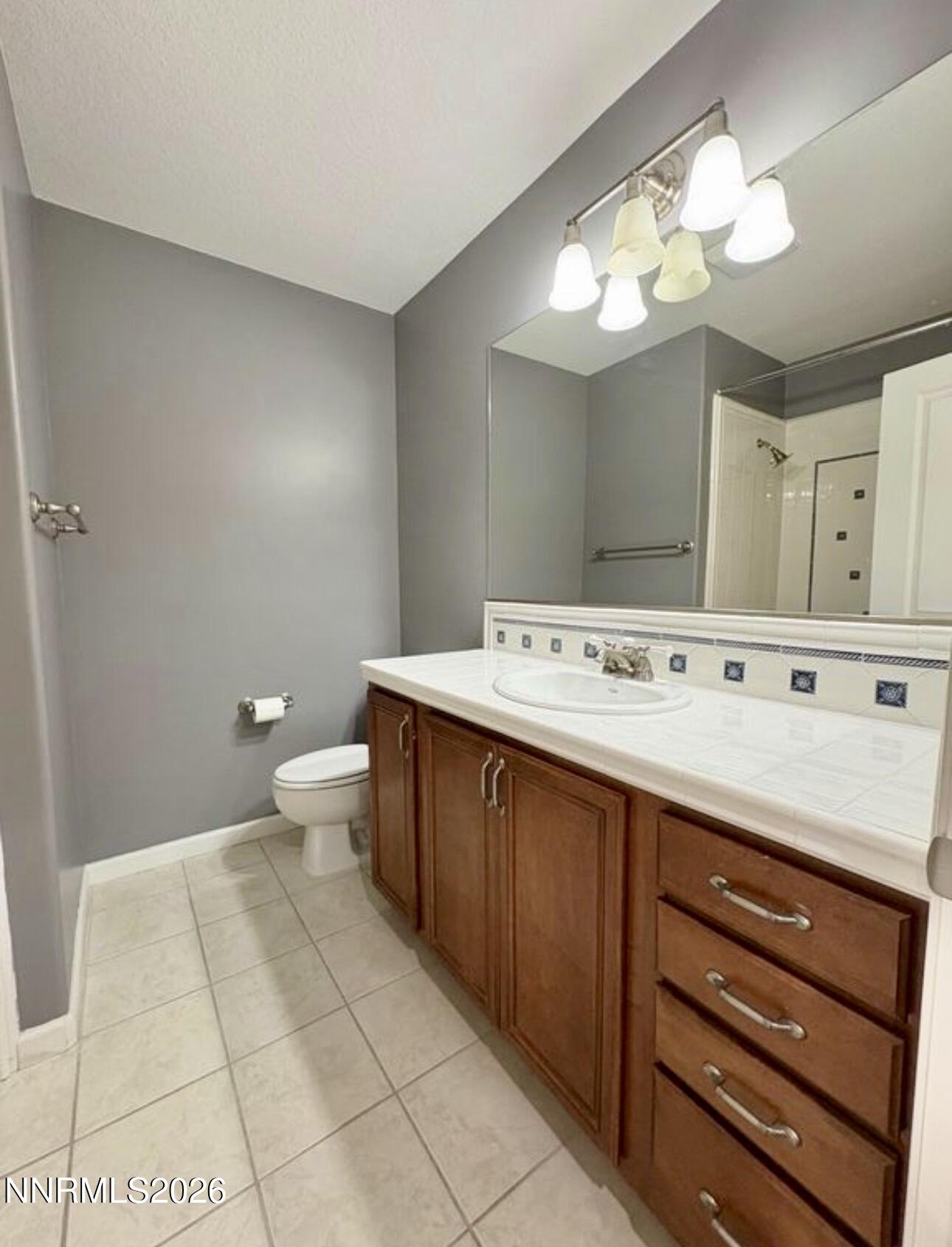 7616 Stone Bluff Way Reno, NV 89523 - Photo 16 of 18 a bathroom with a sink a large mirror and a toilet