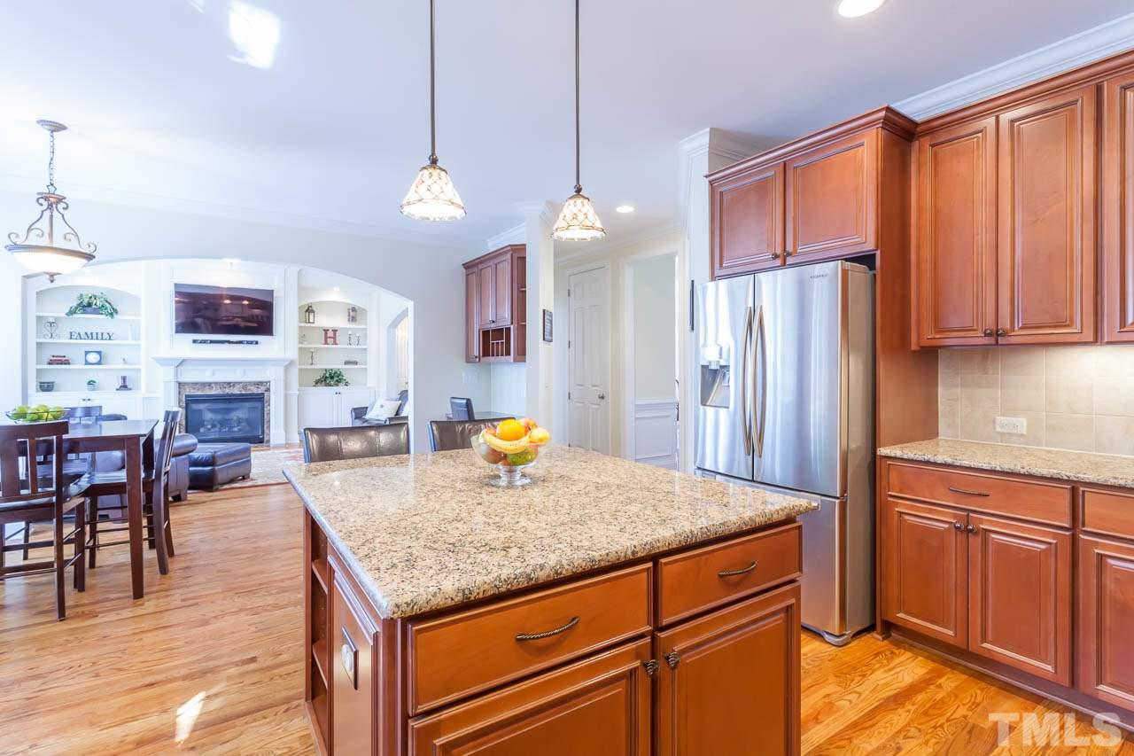 11825 Lowery Ridge Drive Raleigh, NC 27614 - Photo 9 of 25 a kitchen with stainless steel appliances granite countertop a refrigerator a sink dishwasher a dining table and chairs with wooden floor