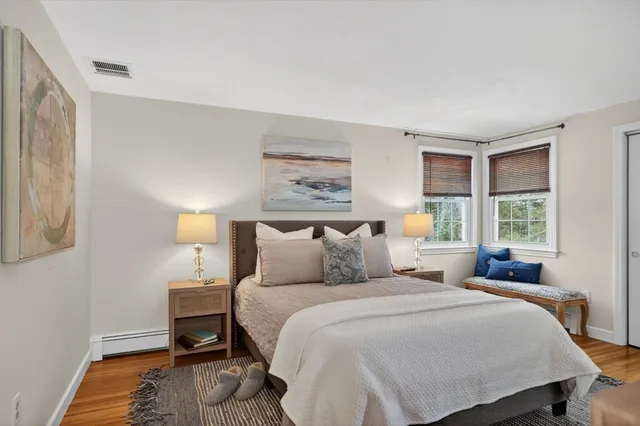 a bedroom with a bed a lamp and a large window