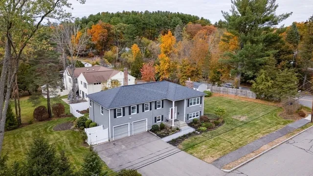 a front view of house with yard and trees around