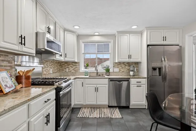 a kitchen with stainless steel appliances granite countertop a refrigerator sink and cabinets