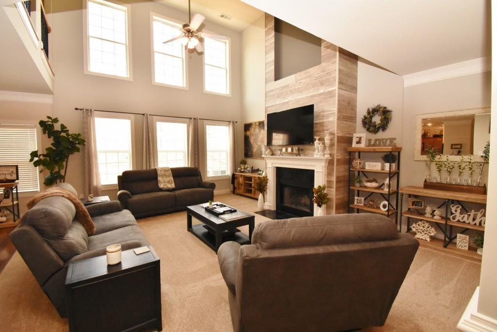 5691 Apple Grove Road Northeast Buford, GA 30519 - Photo 9 of 23 a living room with furniture a flat screen tv and a fireplace