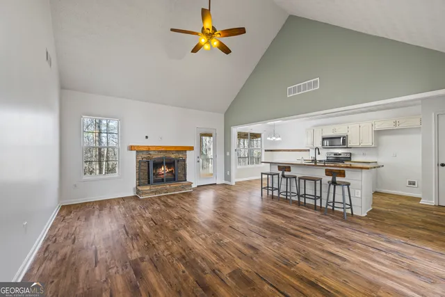 a view of a dining room with furniture a fireplace and wooden floor