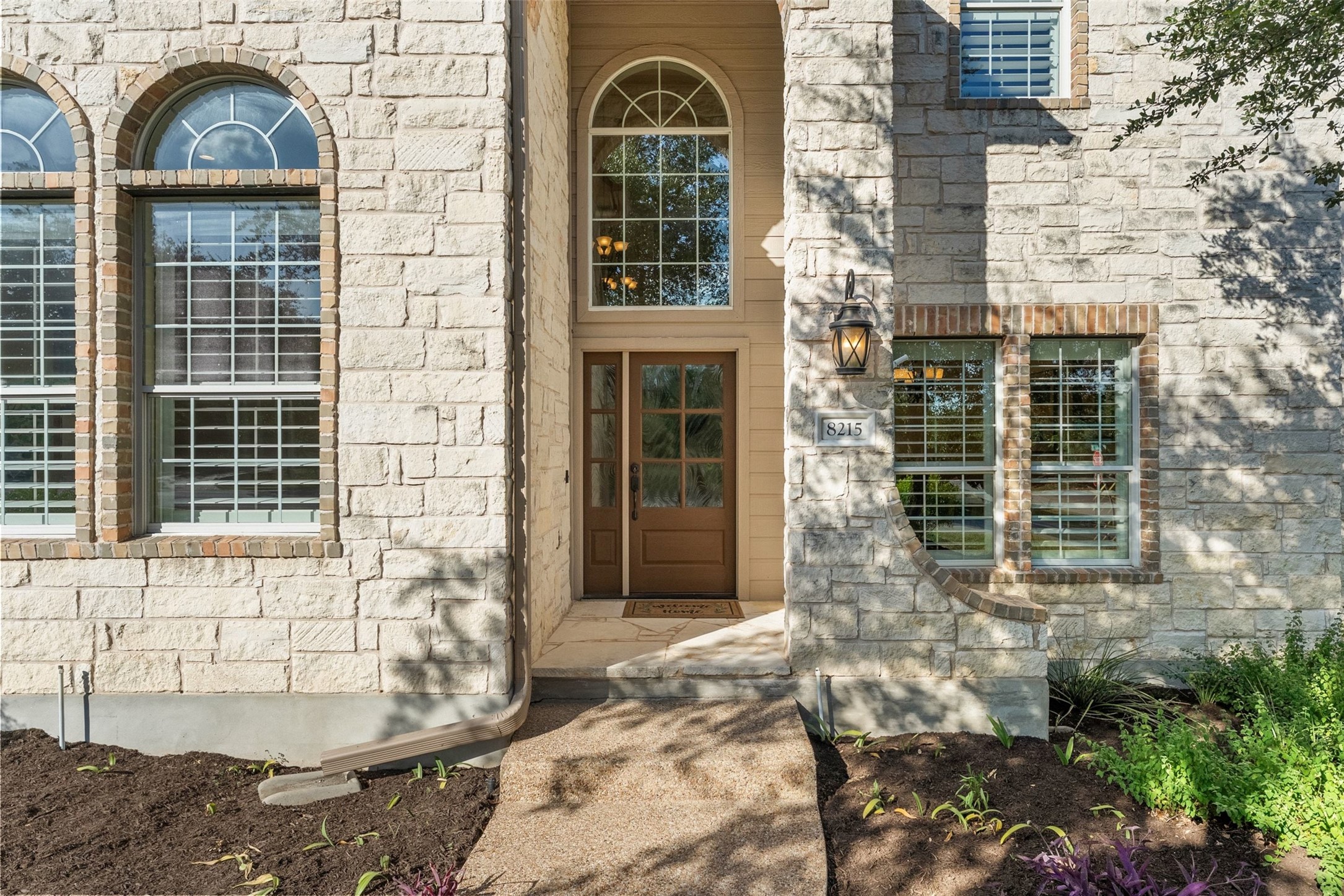 8215 Dark Ridge Cove Austin, TX 78737 - Photo 5 of 40 Elegant stone masonry and an arched transom window define the inviting entrance.