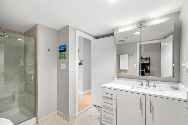 a spacious bathroom with a shower sink and mirror