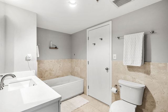 a bathroom with a tub sink toilet and mirror