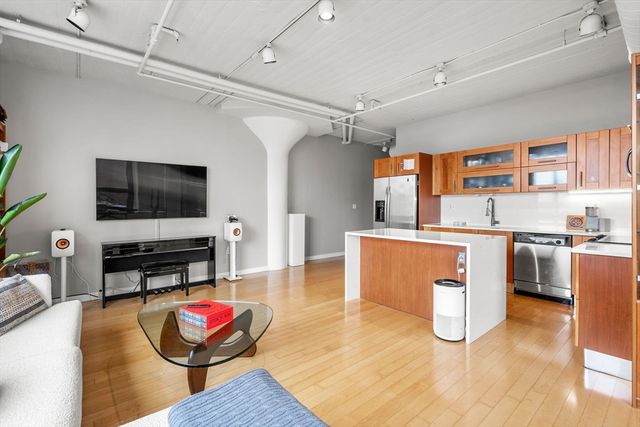 a living room with furniture a flat screen tv and kitchen view