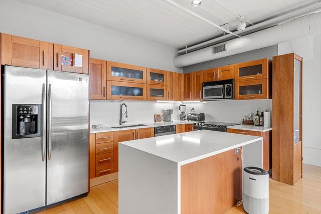 a kitchen with stainless steel appliances sinks a refrigerator and a stove
