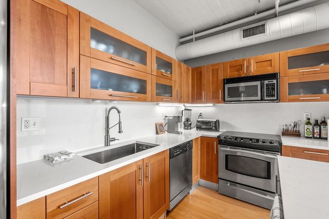 a kitchen with stainless steel appliances granite countertop a stove microwave and sink