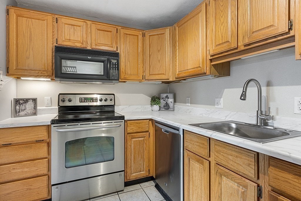 205 Great Road, Unit C1 Acton, MA 01720 - Photo 2 of 18 a kitchen with stainless steel appliances granite countertop white cabinets a stove top oven a sink and dishwasher