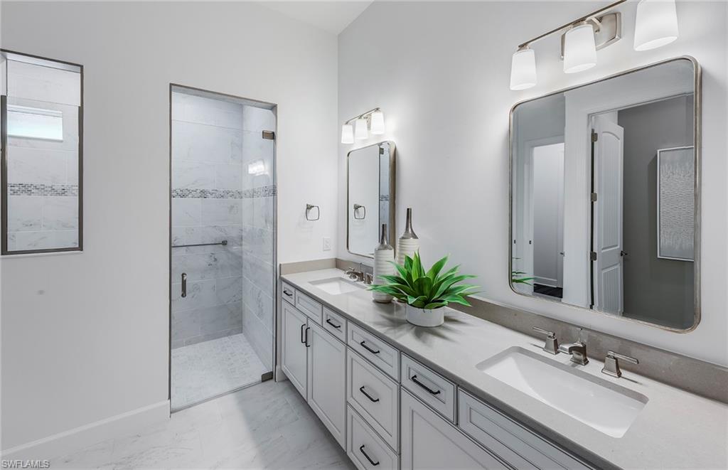 18239 Parksville Drive Estero, FL 33928 - Photo 15 of 38 a bathroom with a double vanity sink mirror and shower