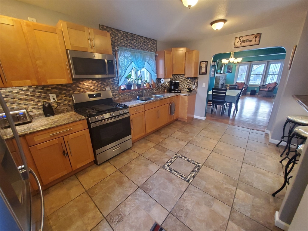 147 Denver Street Springfield, MA 01109 - Photo 4 of 18 a kitchen with stainless steel appliances a stove a sink and a refrigerator