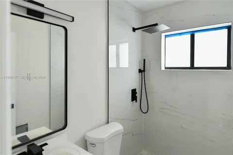 a bathroom with a granite countertop shower and a toilet