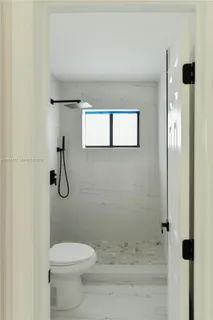 a bathroom with a granite countertop toilet and shower