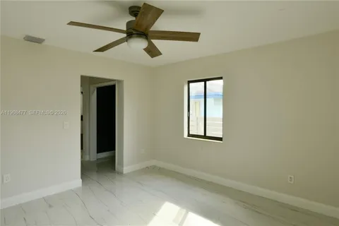an empty room with a window and a fan