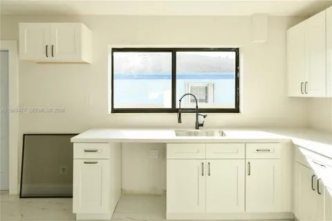 a kitchen with a sink cabinets and a window