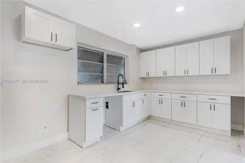 a kitchen with white cabinets and white appliances