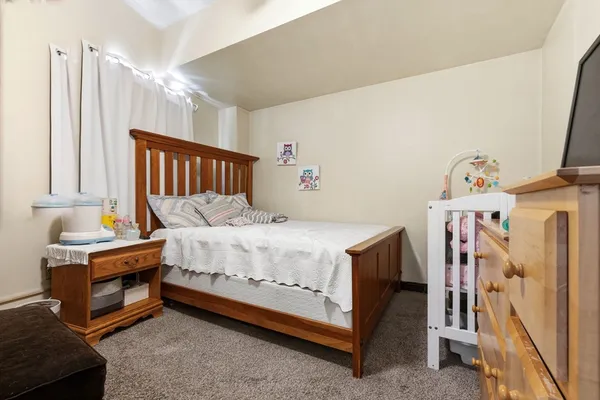 a bed sitting in a bedroom next to a window