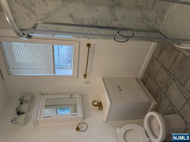 48 Hancox Avenue Nutley, NJ 07110 - Photo 13 of 15 a bathroom with a toilet sink vanity and shower