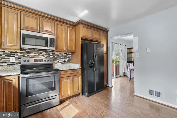 a kitchen with stainless steel appliances granite countertop a refrigerator stove and sink