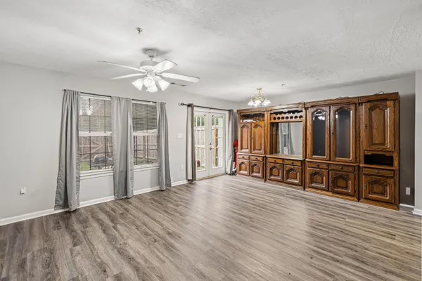 an empty room with wooden floor and windows