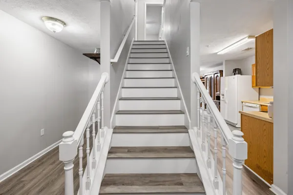 a view of staircase with lots of frames on wall and windows