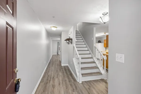 a view of a hallway with wooden floor and staircase