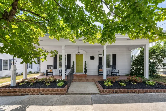 a front view of a house with garden and plants
