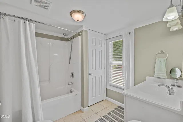 a bathroom with a sink a mirror a bathtub and shower