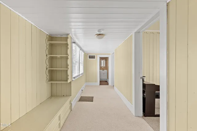 a view of a hallway with wooden shelves