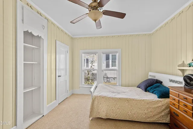 a bedroom with a bed ceiling fan and a window