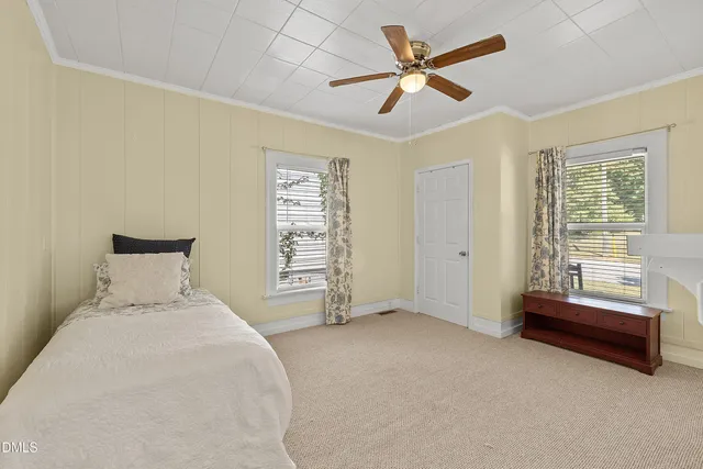 a spacious bedroom with a bed and a ceiling fan
