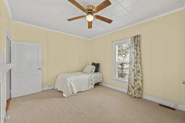 a spacious bedroom with a bed and a chandelier