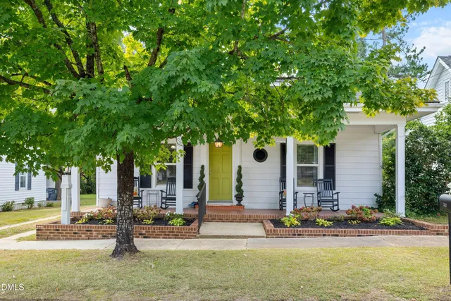 front view of house with a swimming pool and chairs