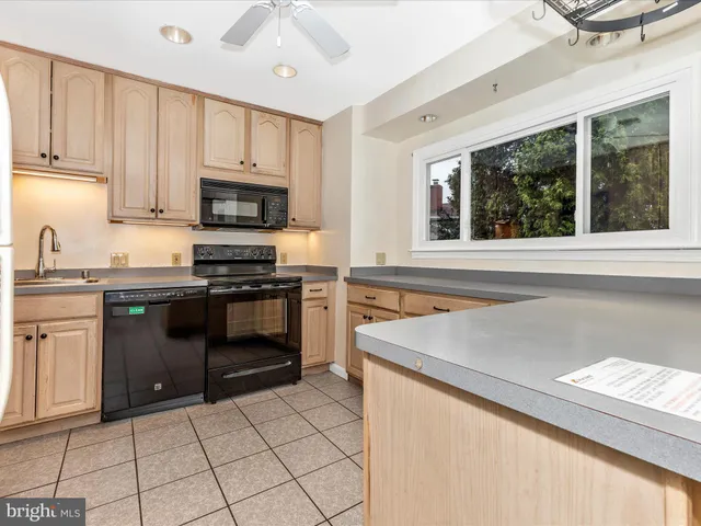 a kitchen with granite countertop a stove sink and cabinets
