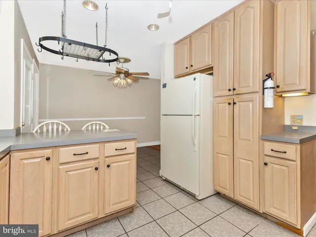 a kitchen with white cabinets and refrigerator