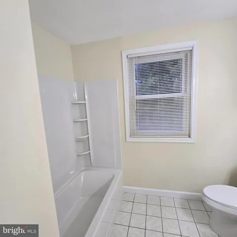 a bedroom with a large bed and a potted plant