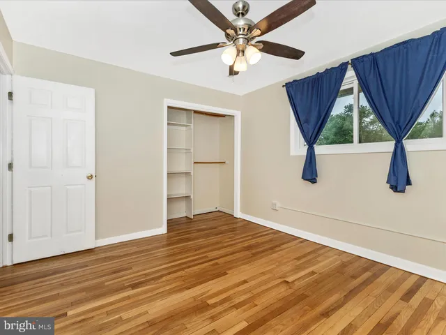 a view of a room with wooden floor and a ceiling fan