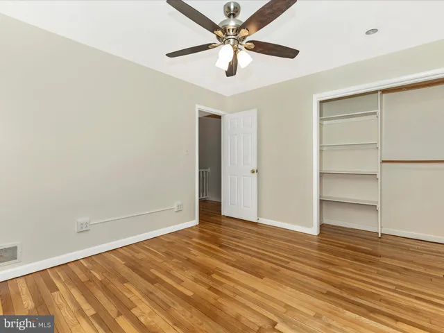 an empty room with wooden floor and closet