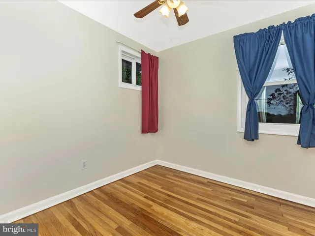 a view of a room with wooden floor and white walls