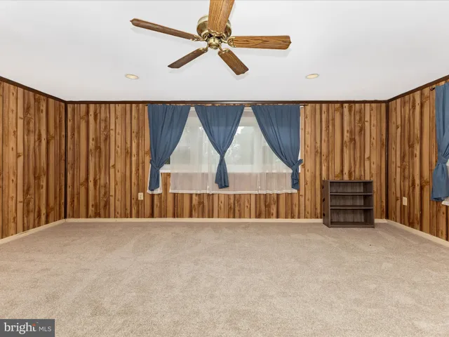a view of an empty room with wooden floor and windows