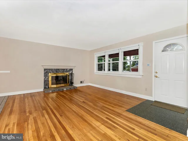 a view of empty room with a fireplace and wooden floor