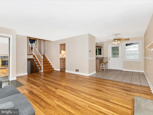 a view of a livingroom with wooden floor and stairs